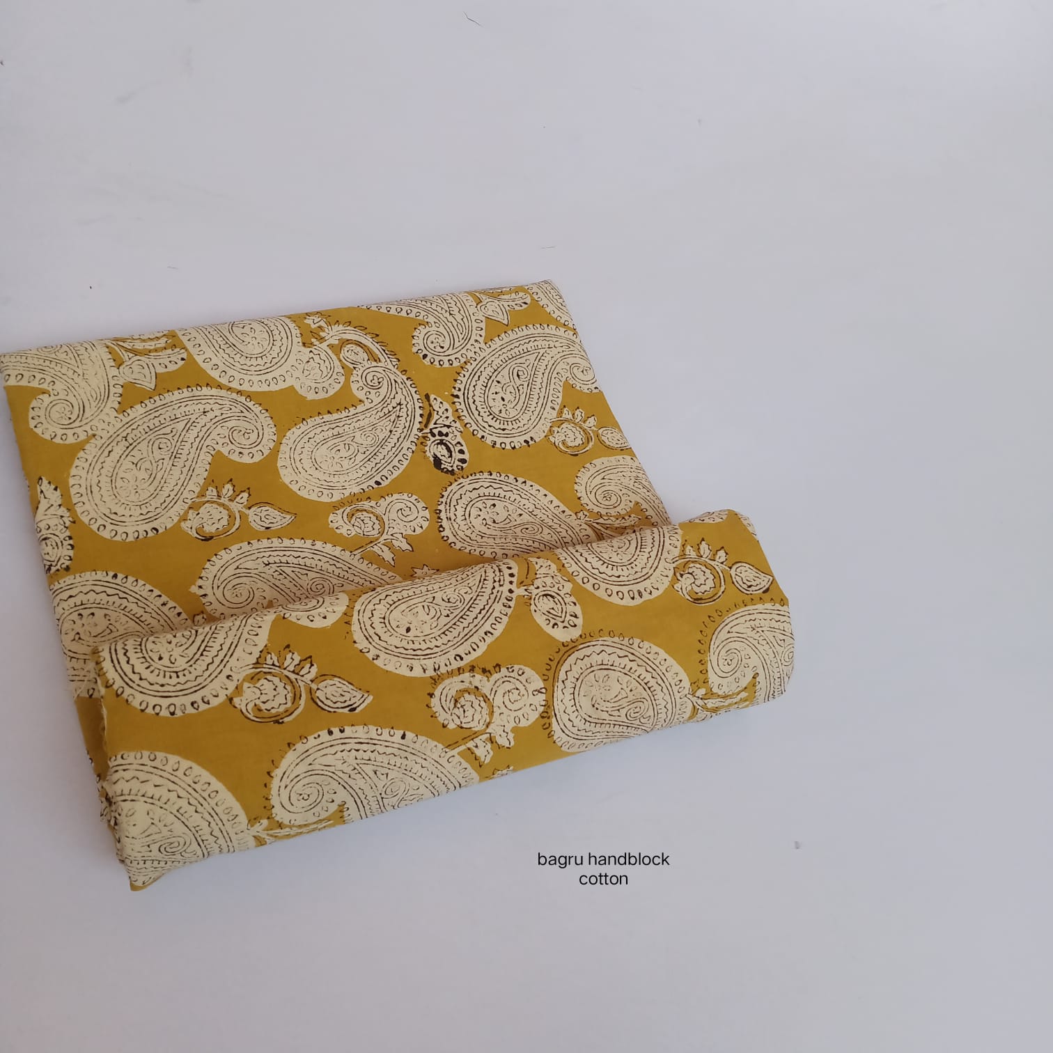Mustard yellow Bagru handblock cotton fabric with oversized paisley pattern, premium wholesale fabric from Fabtexs
